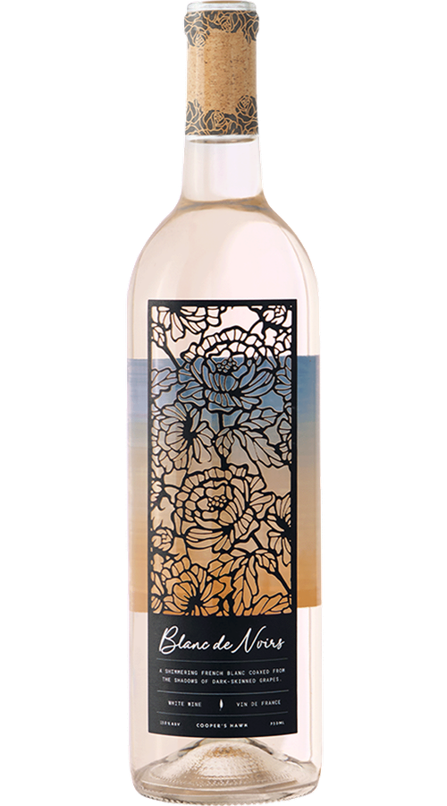 Bottle of Blanc de Noirs white wine with a floral black-and-gold label and cork-style neck, shown upright on a green background.