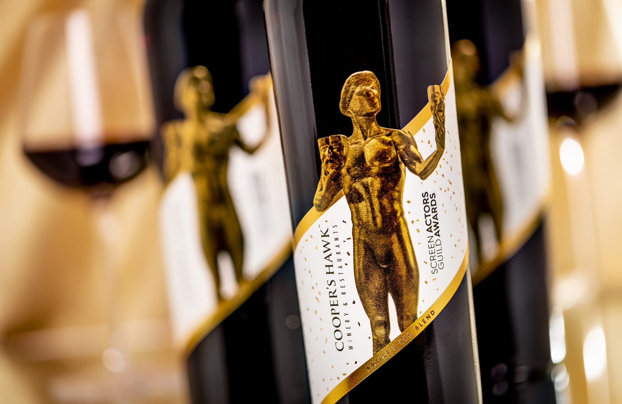 A bottle of wine with a golden statue on it.