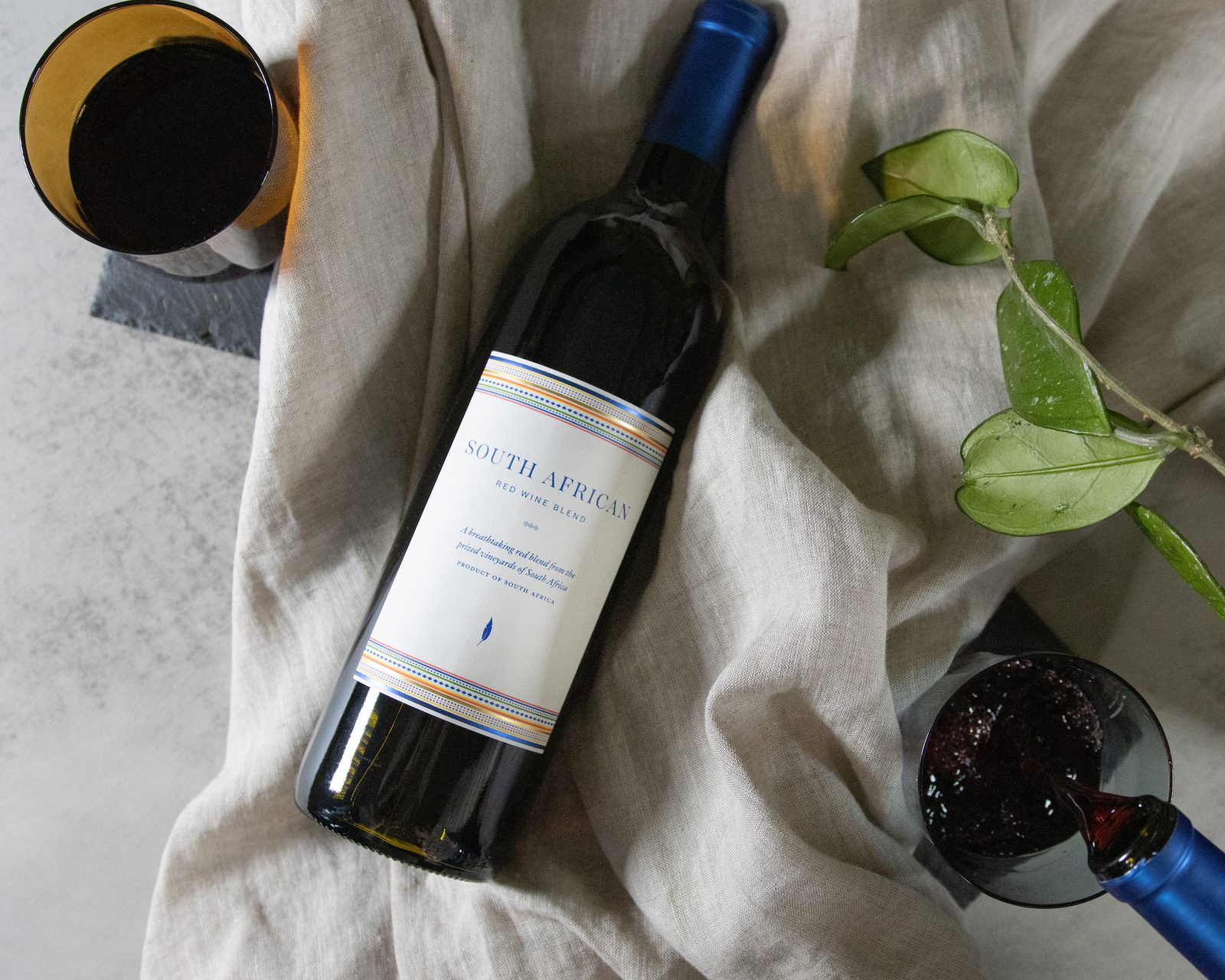 A bottle of wine next to a glass of wine.