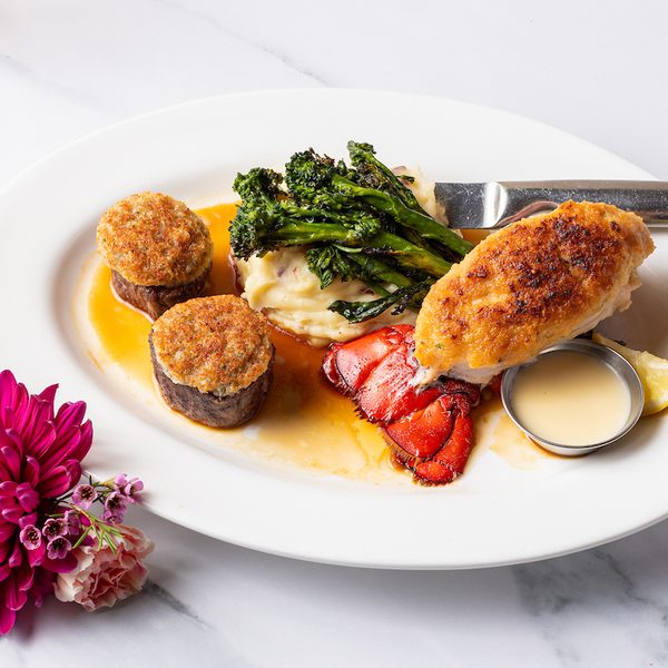 Surf-and-turf: two crab-topped filet medallions, broiled lobster tail, mashed potatoes, broccolini, lemon and sauce.