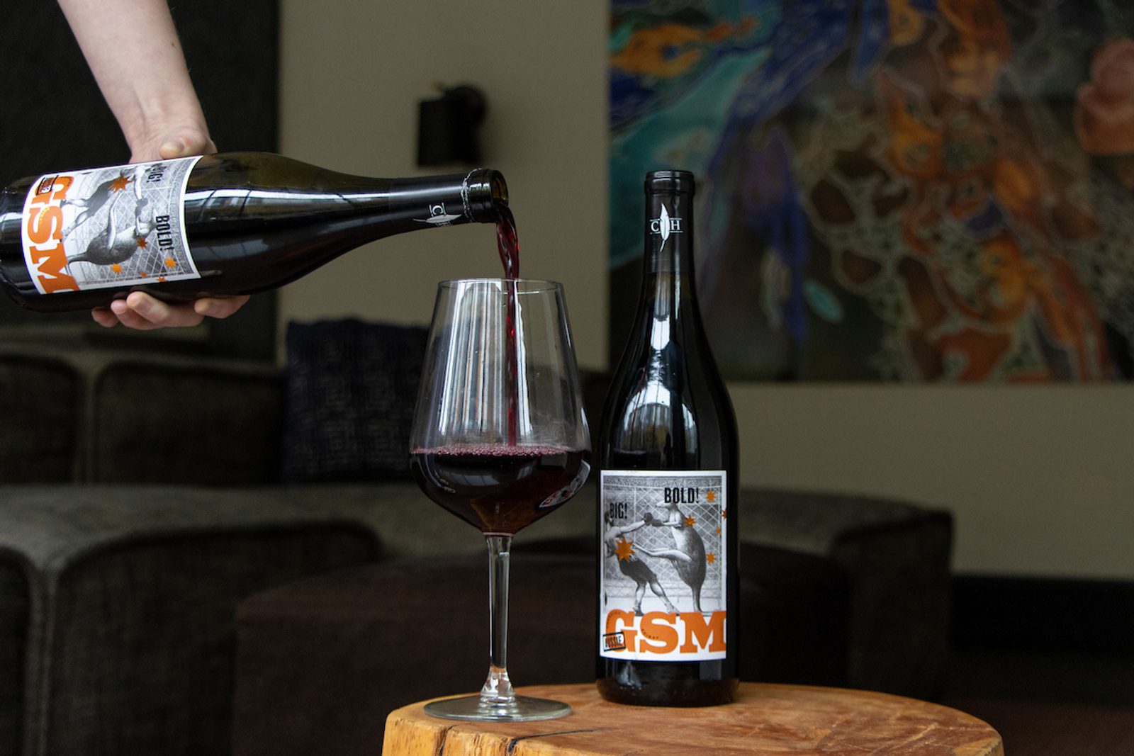 A person pouring wine into a glass.