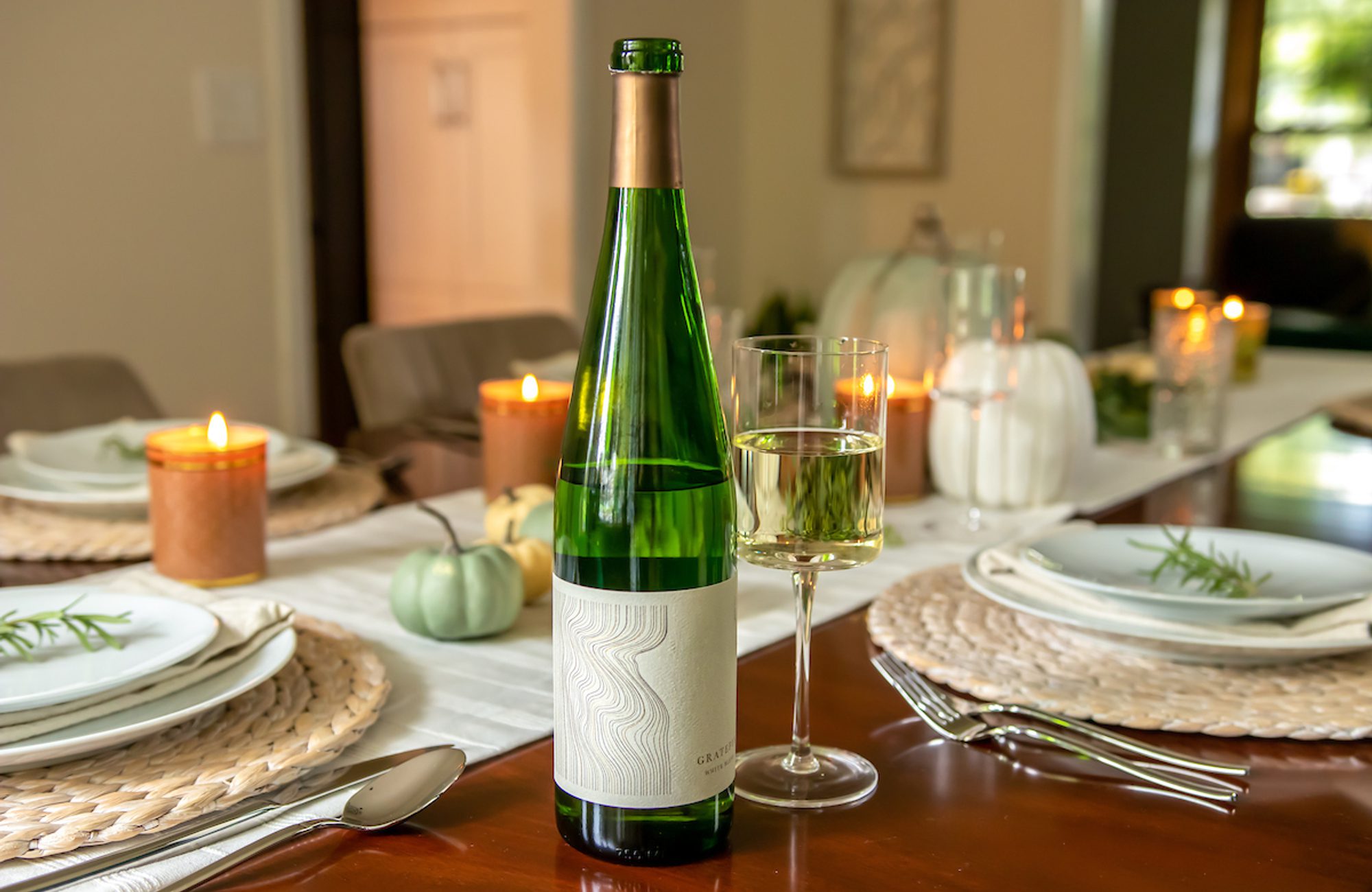 A white wine bottle sits on a table.