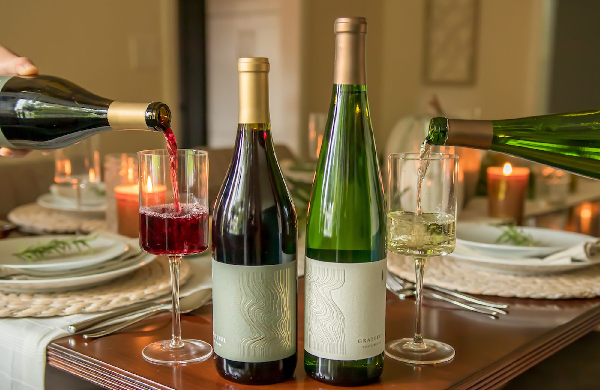 A group of wine bottles pouring into glasses.