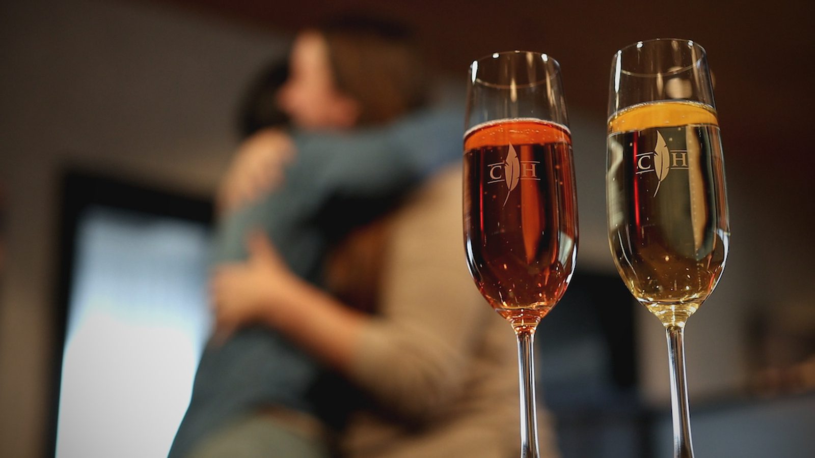 Image of people hugging with champagne glasses in front of them