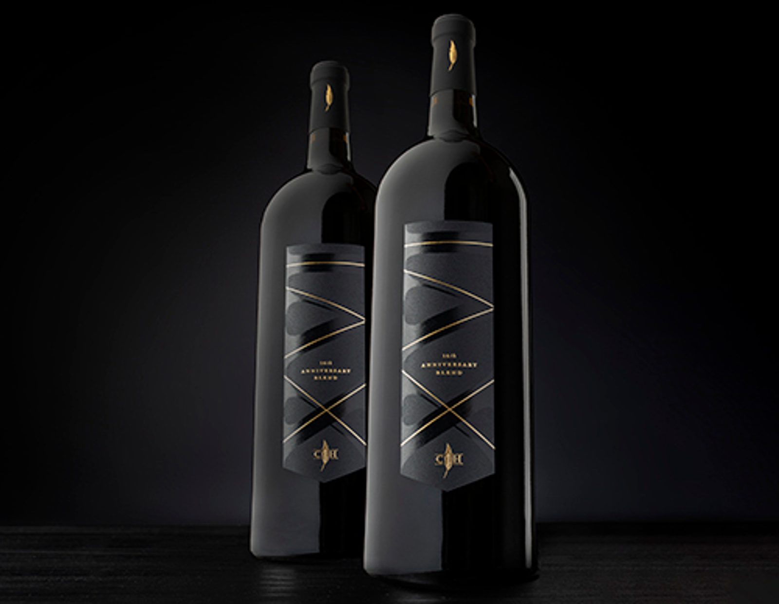 Two bottles of wine on a dark background.