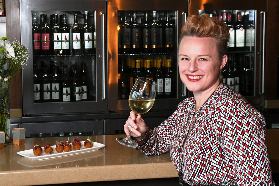 A woman holding a glass of wine.