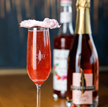 Rose glass with bottles in the background