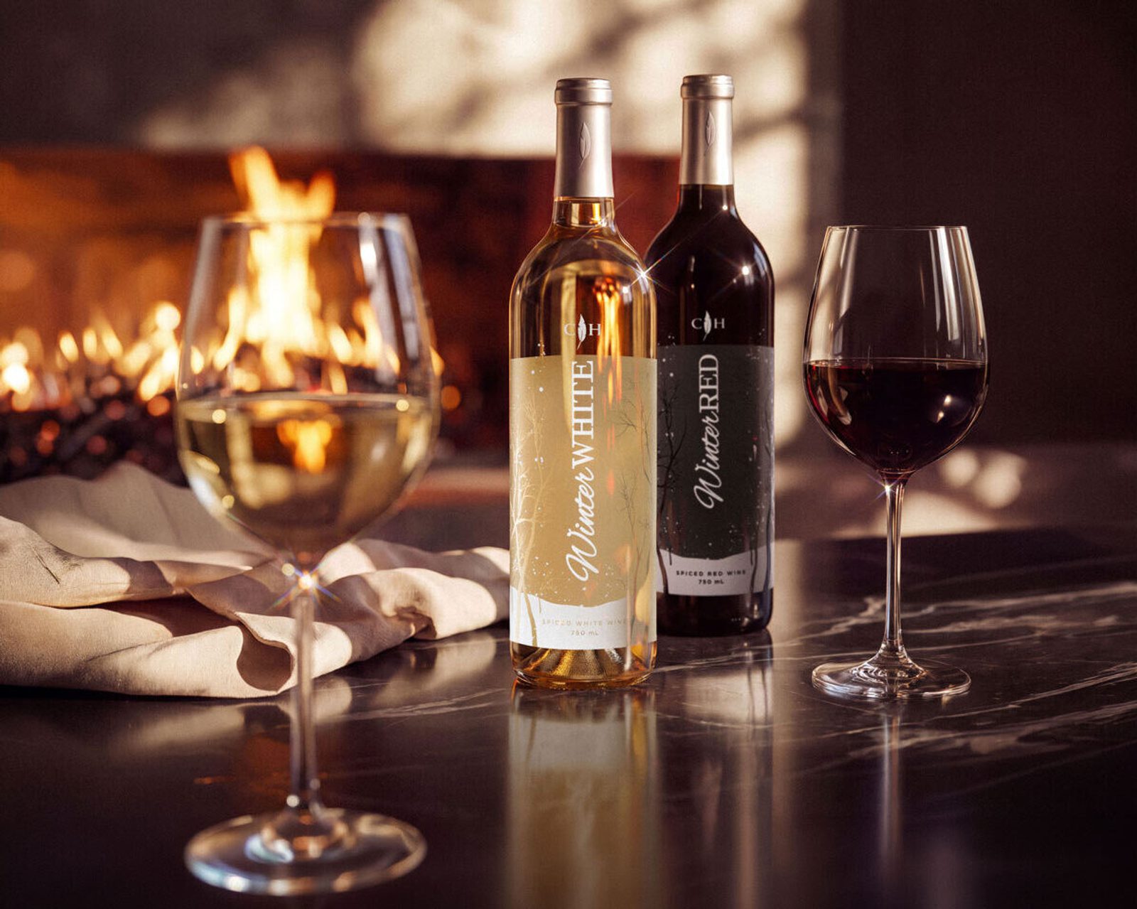 Two wine bottles labeled Winter White and Winter Red beside two filled wine glasses on a table, with a glowing fireplace in the background.