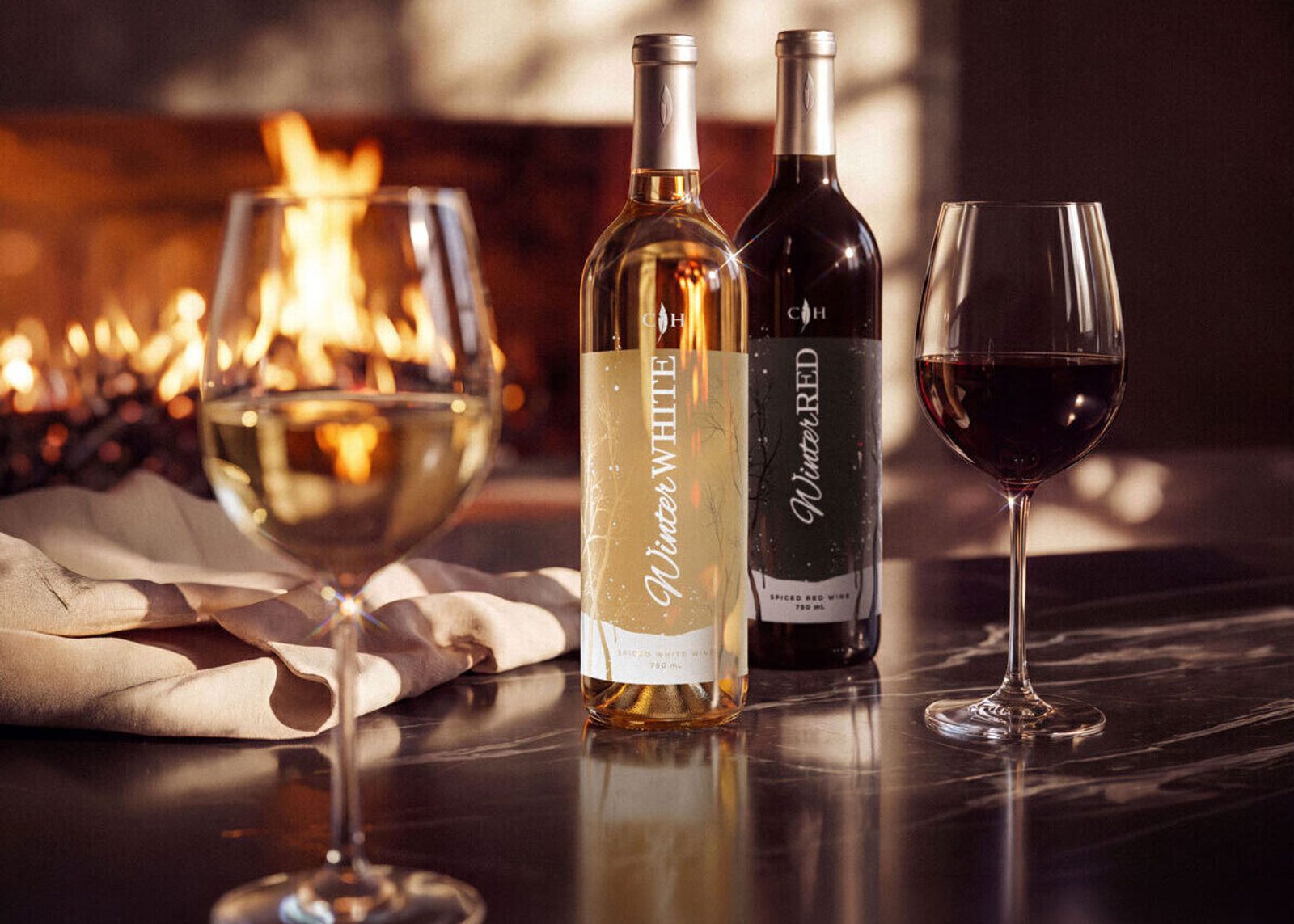 Two wine bottles, one white and one red, beside filled wine glasses on a reflective table, with a warm fireplace glowing in the background.
