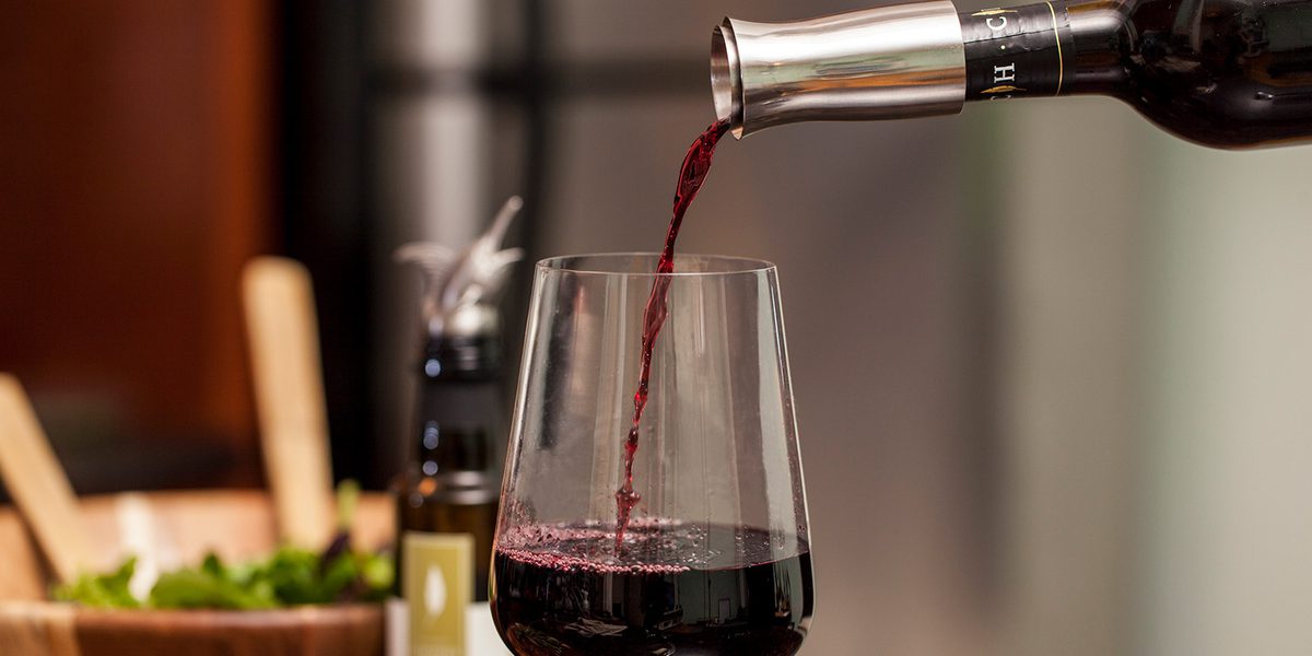 A person pouring wine into a glass.