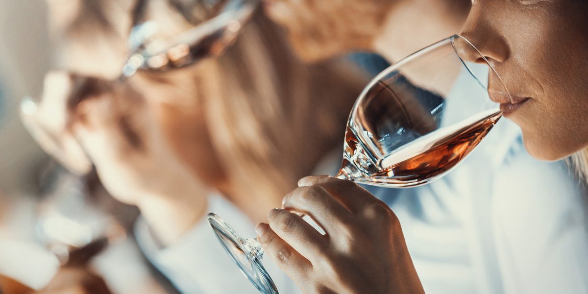 A group of people drinking wine in a line.