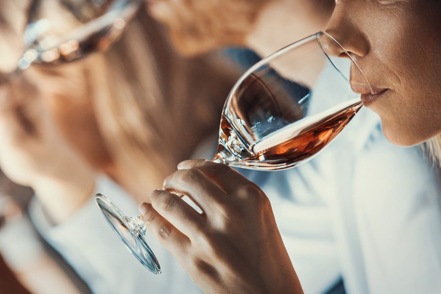 A group of people drinking wine in a line.