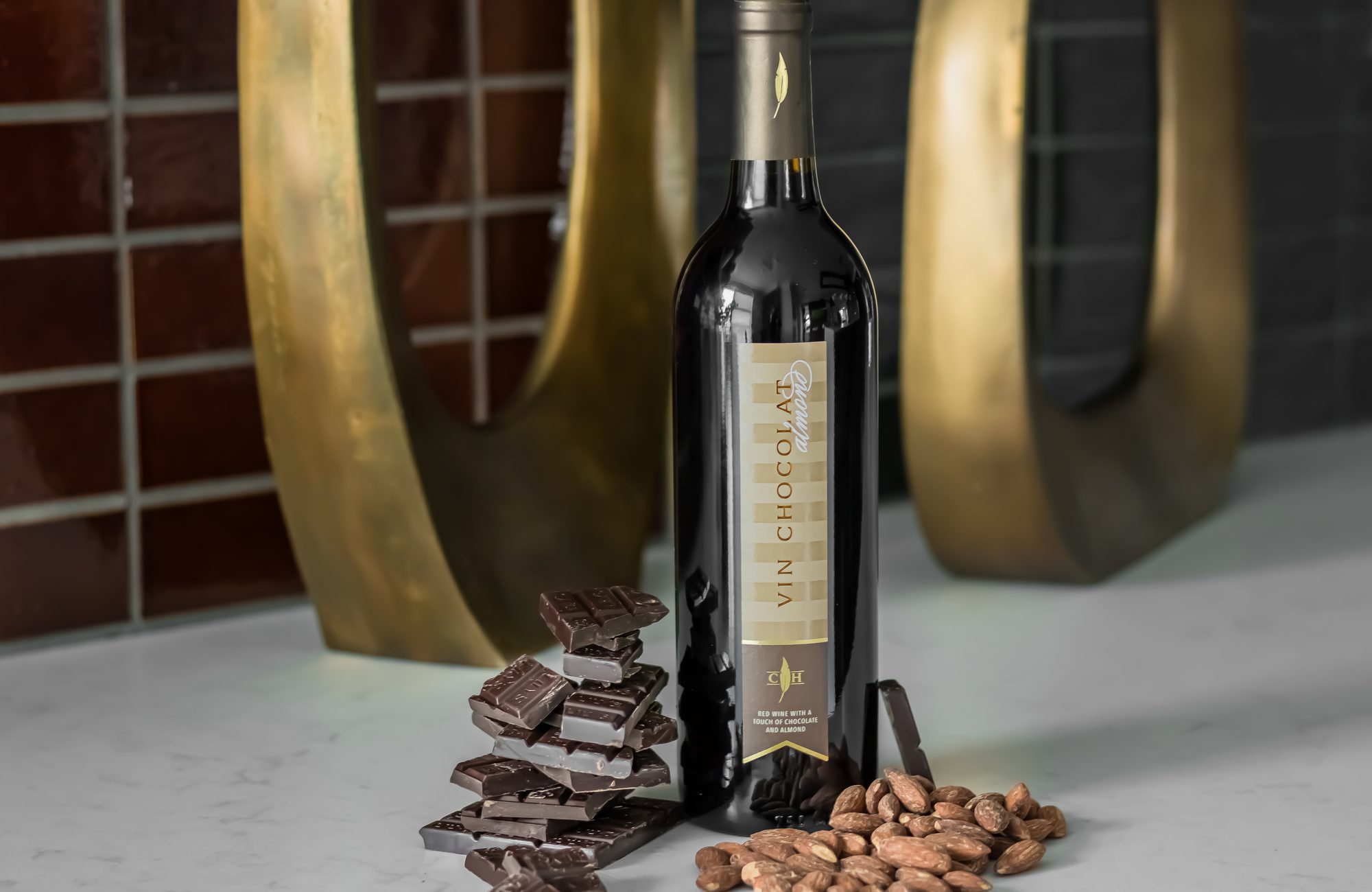 A bottle of dark chocolate and nuts on a counter.