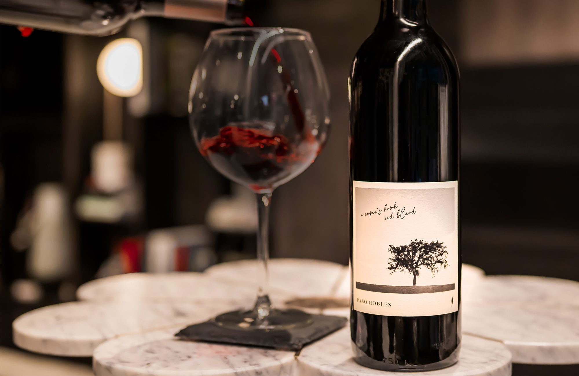 A bottle of wine is being poured into a glass.