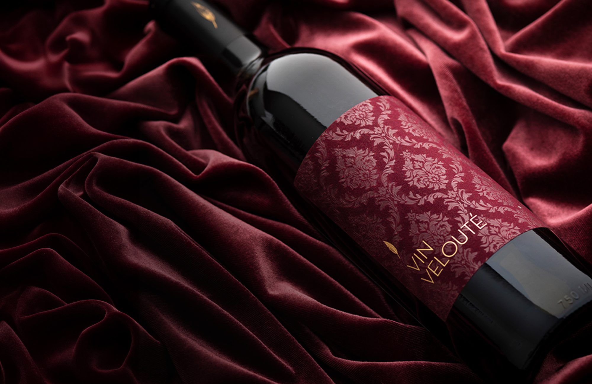 A bottle of red wine on a velvet fabric.