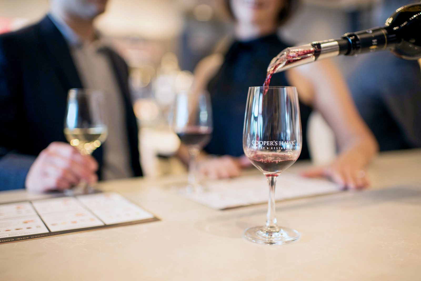 A man pouring wine into a glass.