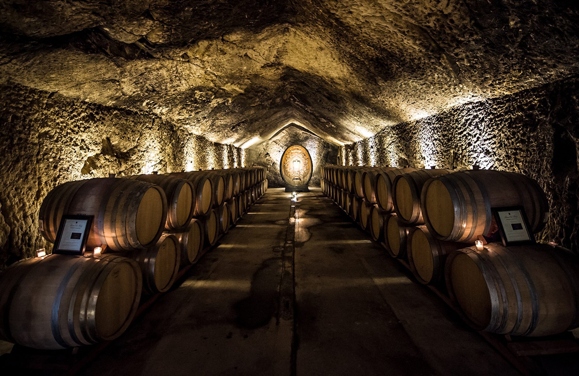 Wine barrels lined up in a cave.