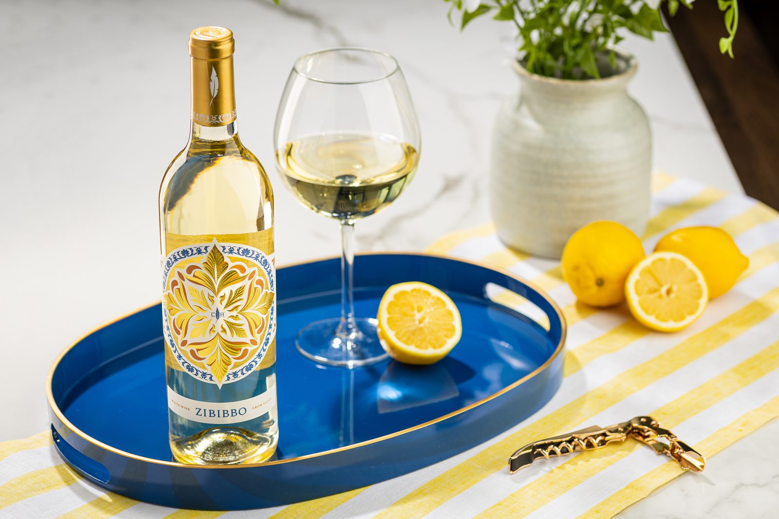 Zibibbo Bottle Image with a glass of wine and lemons on the table