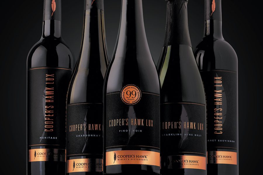 Five bottles of wine on a black background.